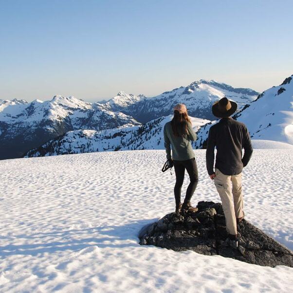 people enjoying a snowy hike in a mountain on a helicopter hiking tour near Tofino Vancouver Island